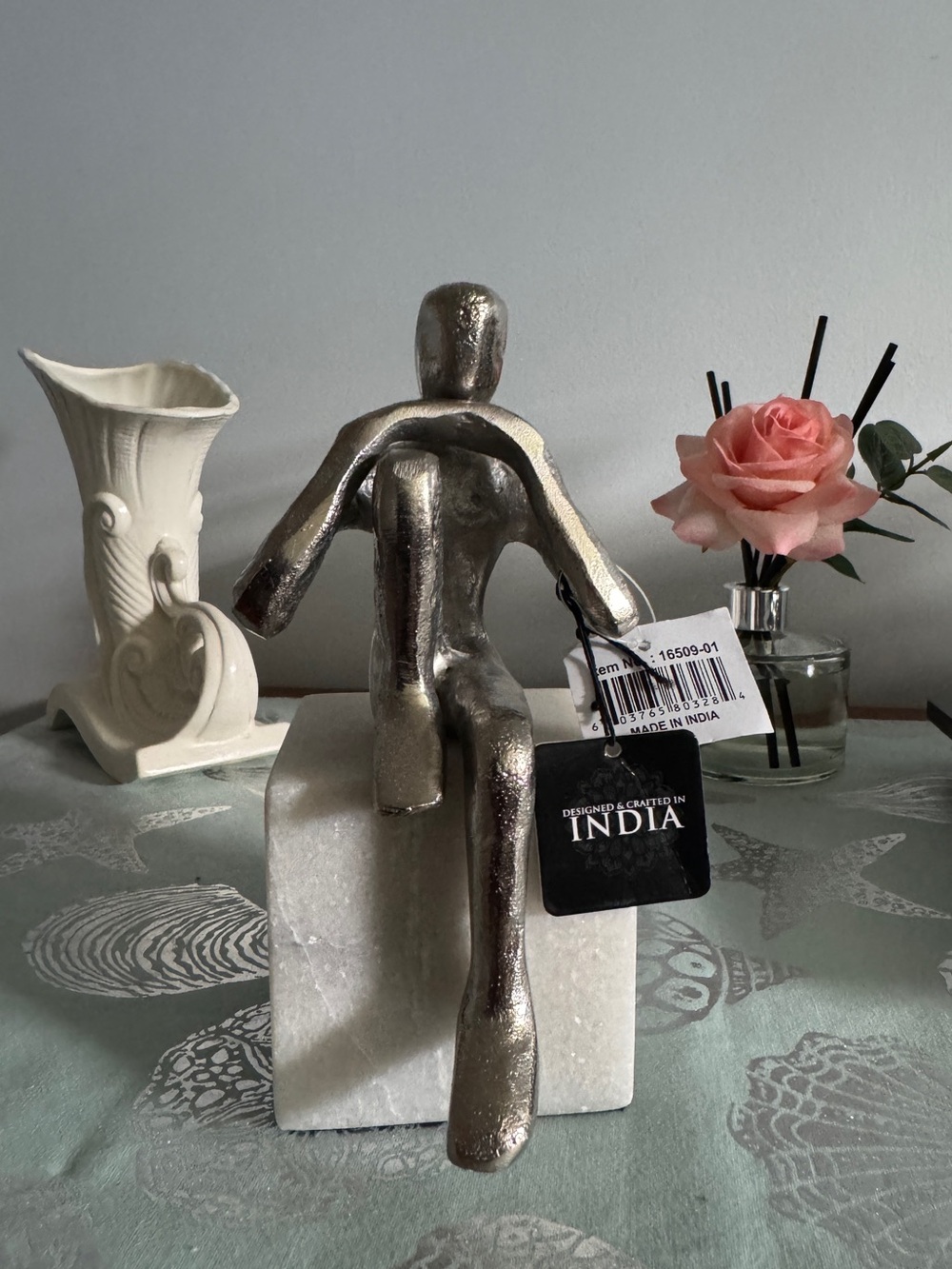 Silver Metal Abstract Sitting Sculpture on White Marble Base